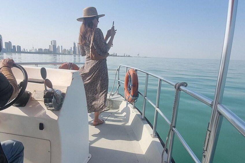 A person on a boat, a lifebuoy, and a city skyline in the background. 1