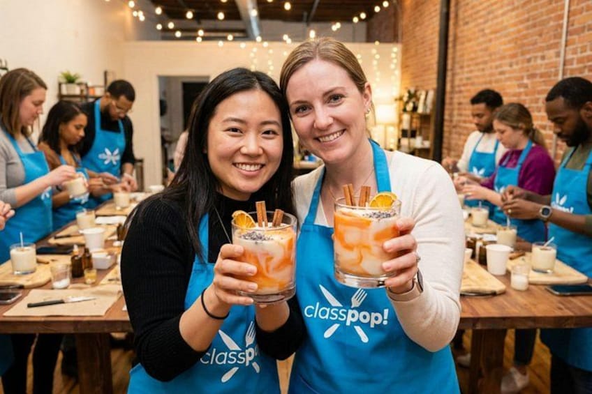 Dos personas sosteniendo bebidas con un delantal que dice 'classpop!', en una habitación con paredes de ladrillo y mesas de madera. 1