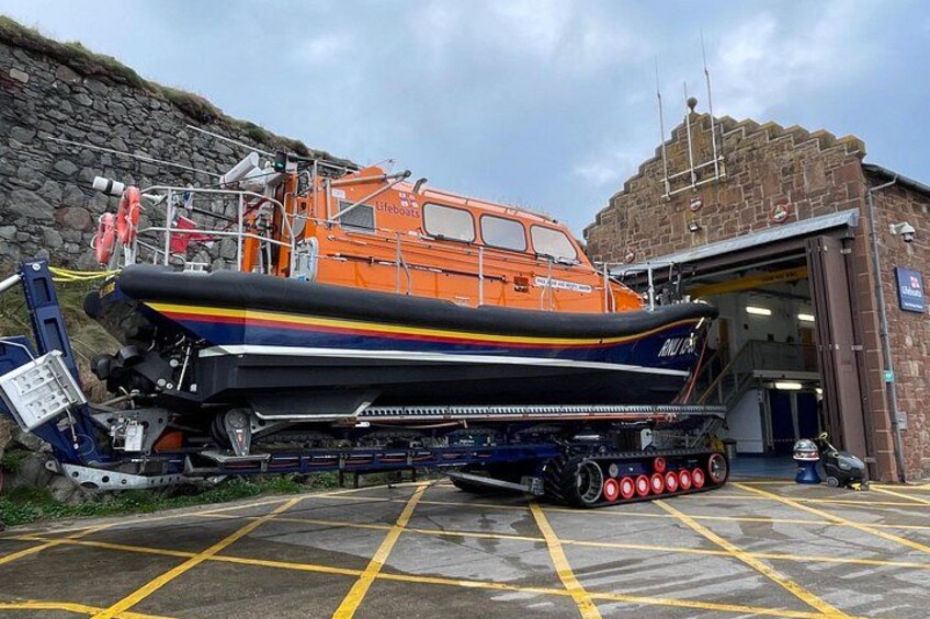 A lifeboat on a trailer in front of a building. 2