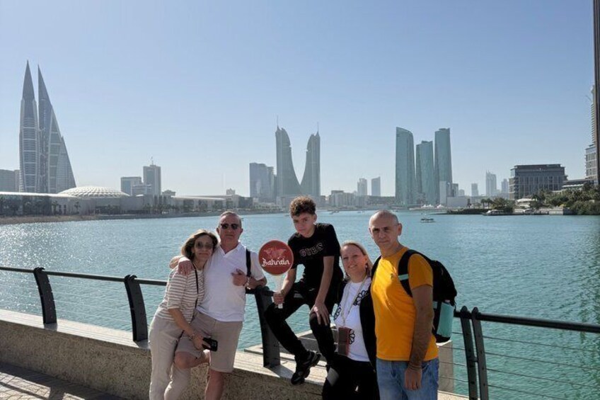 A group of people posing by a waterfront with a city skyline in the background. 5