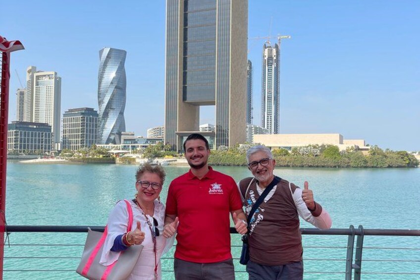 Three people standing on a boat with a city skyline in the background. 5