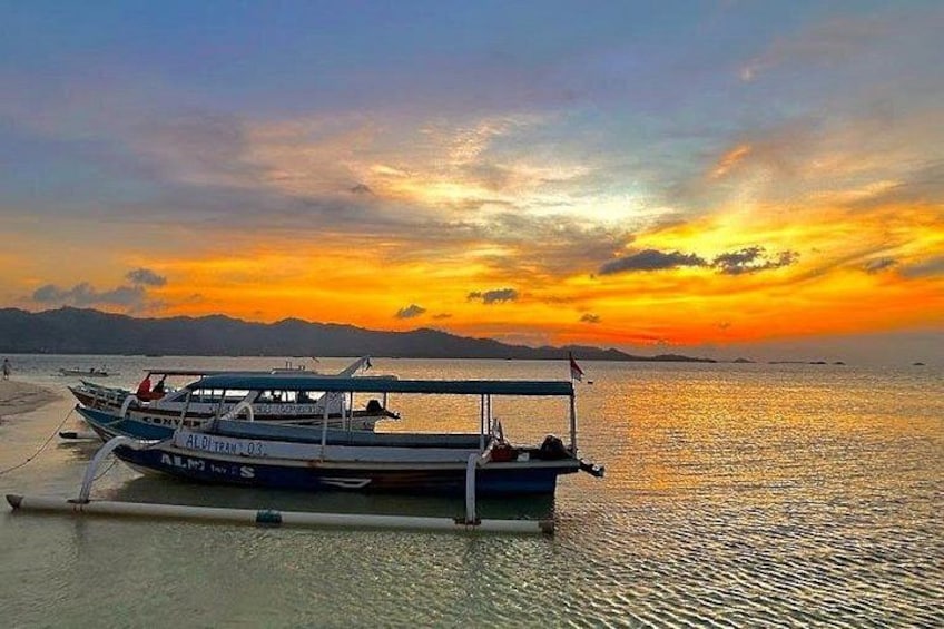 A boat on a calm body of water with a sunset in the background. 5