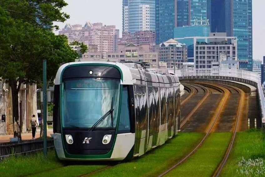A train on tracks with a cityscape in the background. 5