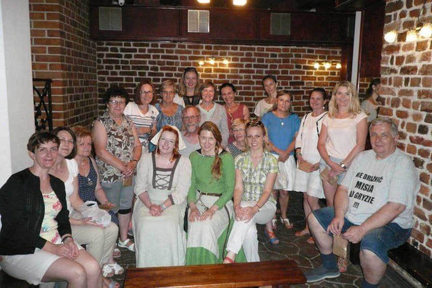 A group of people in a brick-walled indoor setting. 2