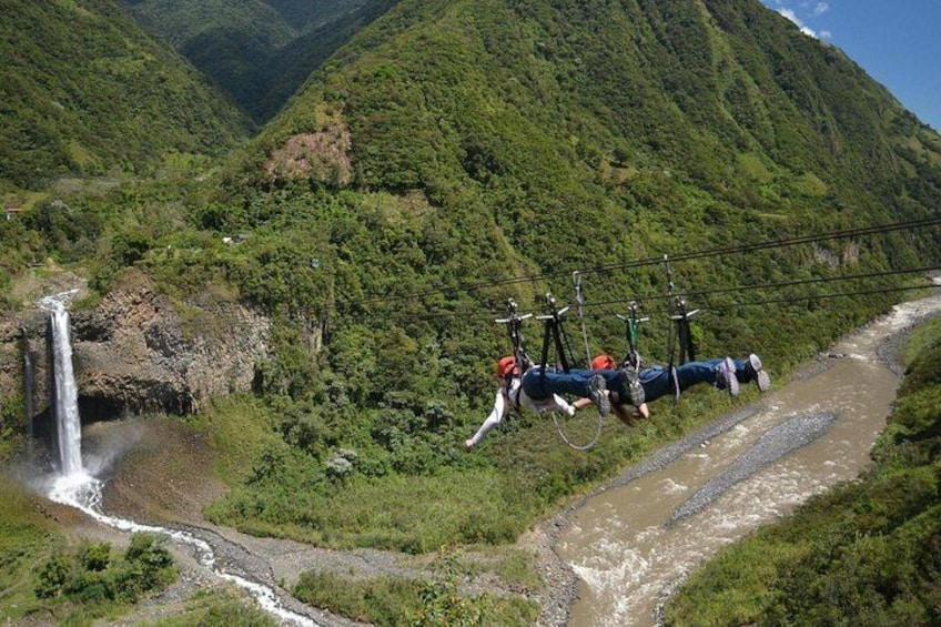 A suspension bridge with cyclists, a waterfall, and a river. 2