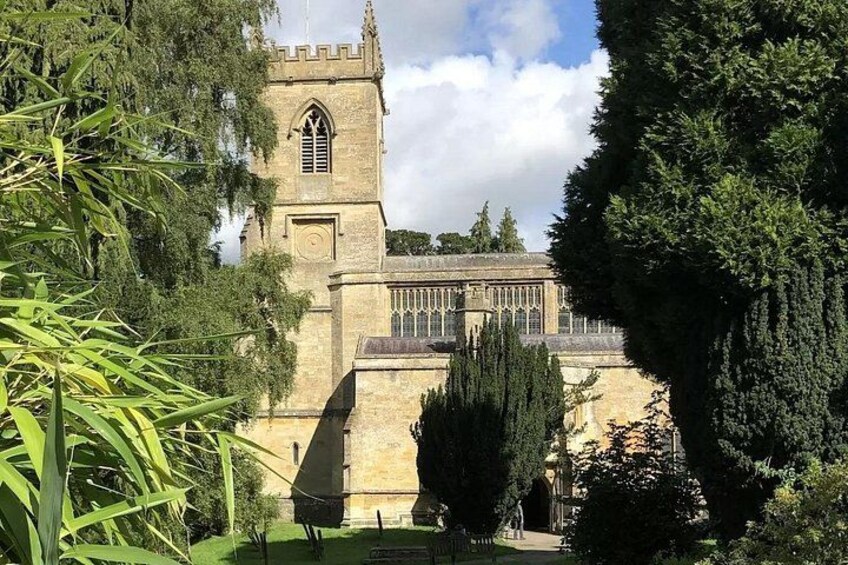 A historic building with a clock tower, surrounded by trees and greenery. 4