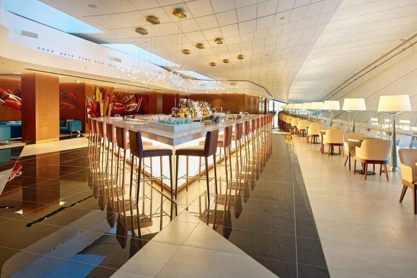 Un interno ristorante moderno con un bancone centrale, soffitto alto e pavimento riflettente. 2