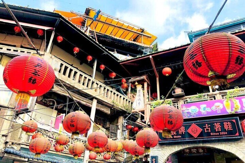 A traditional building with red lanterns and a signboard. 1