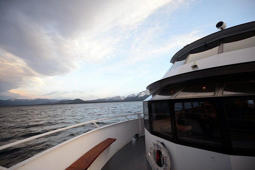 A boat's deck with a view of the water and distant mountains. 4