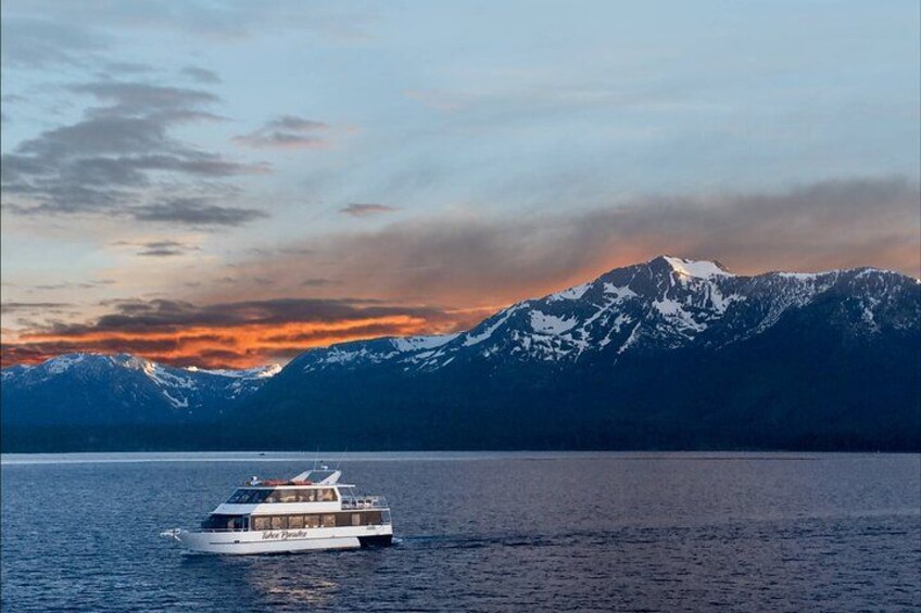 A boat on a calm lake with snow-capped mountains in the background. 1