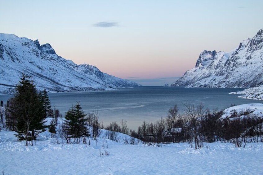A snow-covered landscape with a lake and mountains. 2