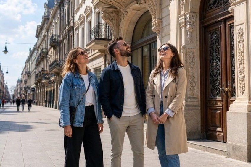 A couple and a woman walking on a city street with historic buildings. 3