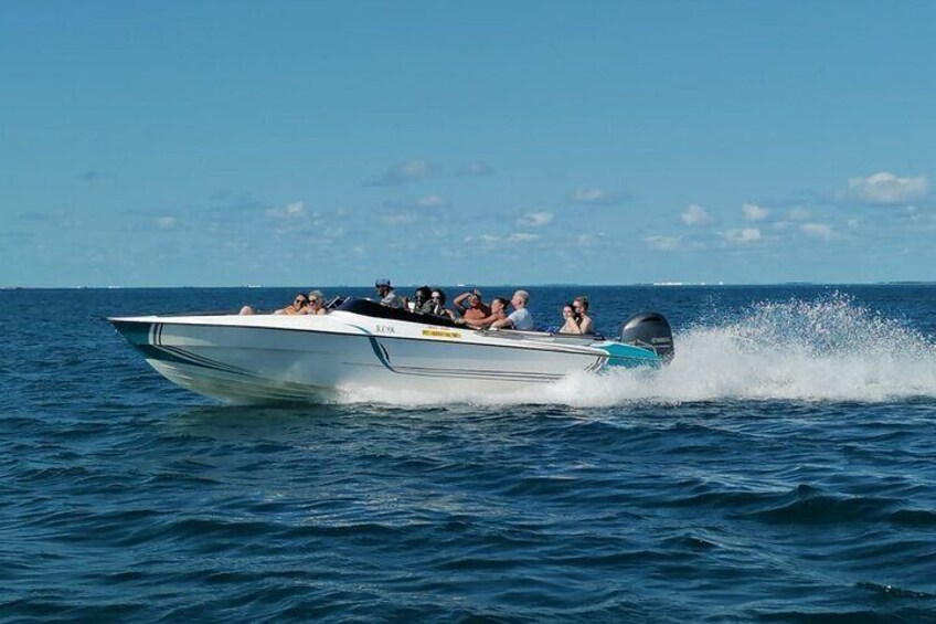 A speedboat with passengers on a clear day. 2