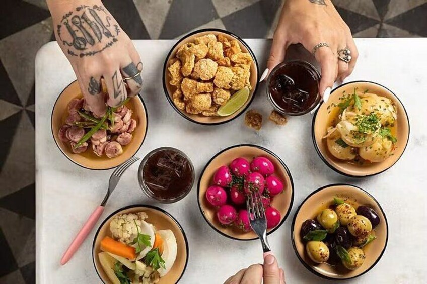 Ein Tisch mit verschiedenen Gerichten, darunter eine Fleischschale, eine Schale mit Croutons, eine Salatschale und eine Fruchtschale. 4