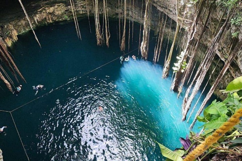 Cuerpo de agua azul cristalina rodeado de acantilados rocosos y vegetación. 5