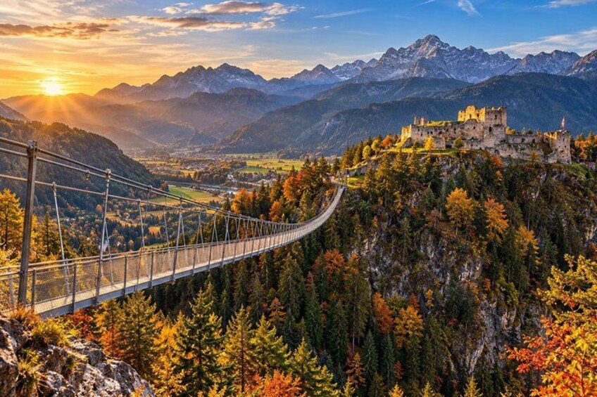 Un pont suspendu, le feuillage automnal et un château perché sur une montagne. 2
