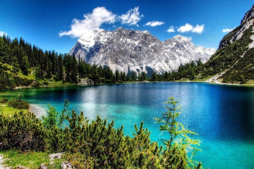 A mountain lake surrounded by forest and snow-capped peaks. 3