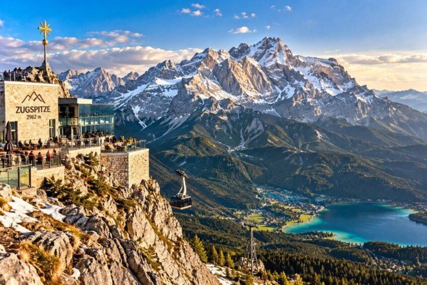 A mountain peak, a lake, and a building with the text 'ZUGSPITZE 2962 m'. 1