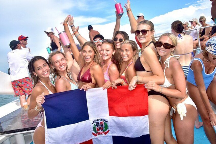 A group of people on a boat, holding a flag. 5