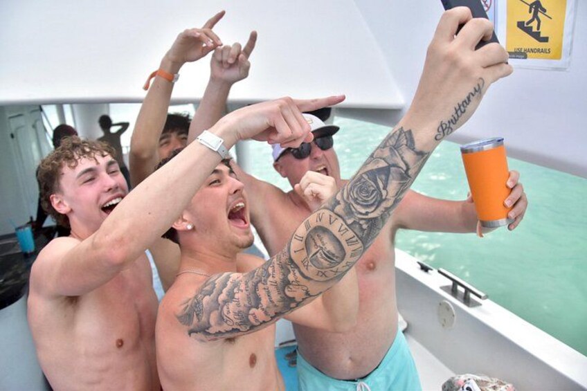 People on a boat, some with tattoos, holding a drink. 3