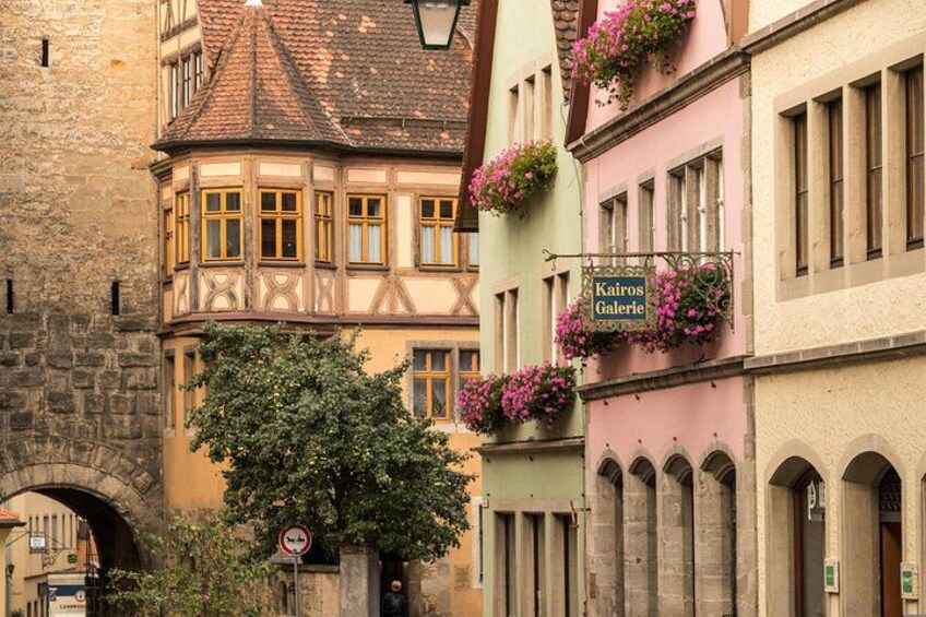 A traditional European street with a half-timbered building, a sign for 'Kairo's Galerie,' and a no parking sign. 3