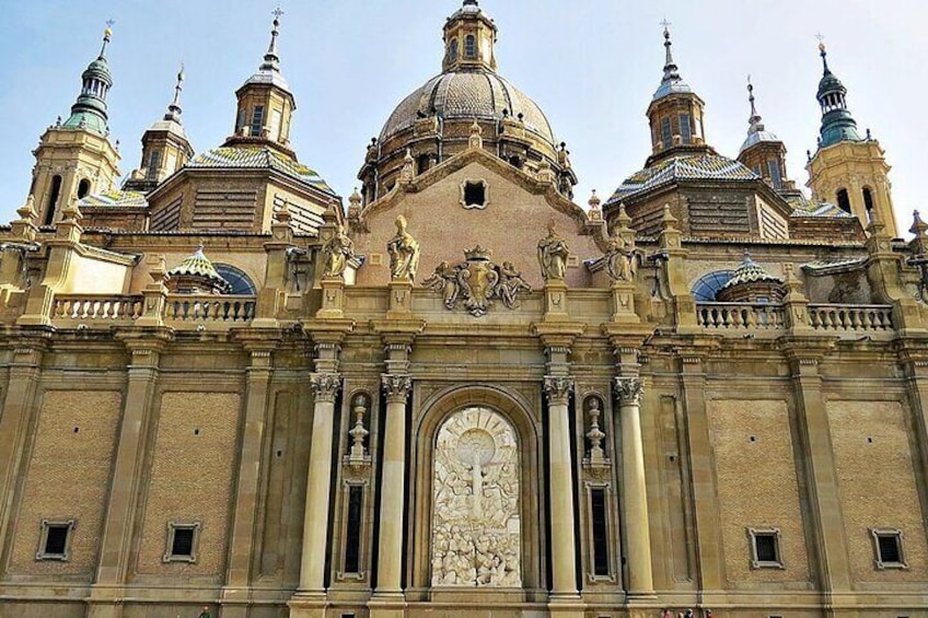 A grand historical building with a large central dome, multiple smaller domes, and ornate statues. 1