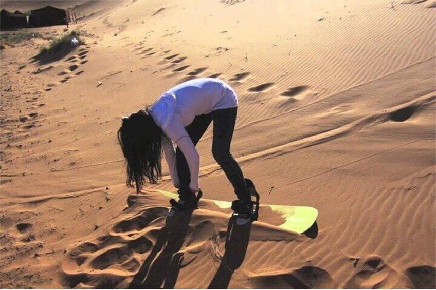 A person snowboarding on a sandy dune. 5