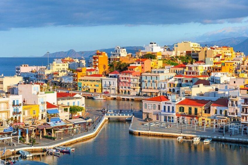 Une ville côtière aux bâtiments aux couleurs vives, dotée d’un port tranquille et d’un pont qui relie la ville au continent. 3