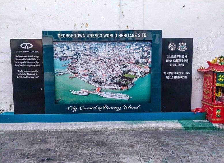 A signboard for the George Town UNESCO World Heritage Site, featuring an aerial view of the city and the City Council of Penang Island. 3