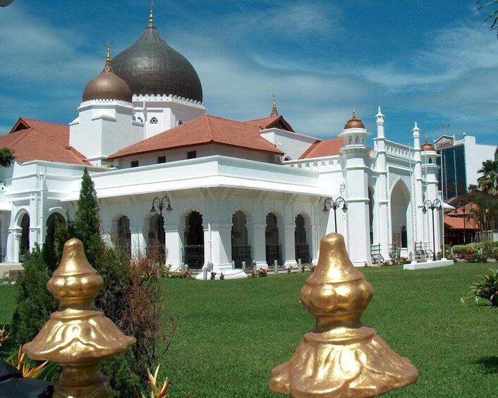 A white building with domes and red roofs, surrounded by greenery. 4