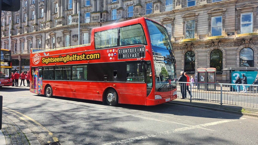 A red double-decker bus with the text "Sightseeing Belfast.com" and "SIGHTSEEING BELFAST" on its side. 3