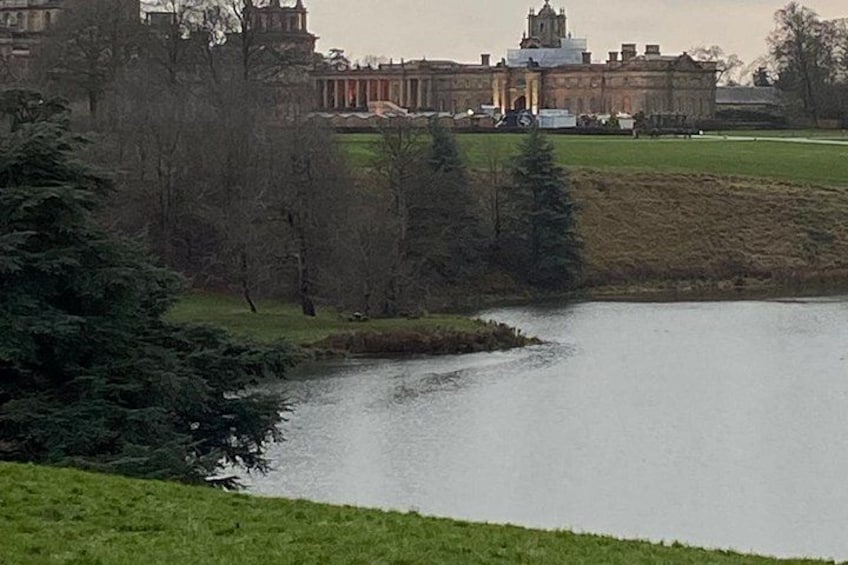 A large building with a dome, a body of water, and a grassy area. 5