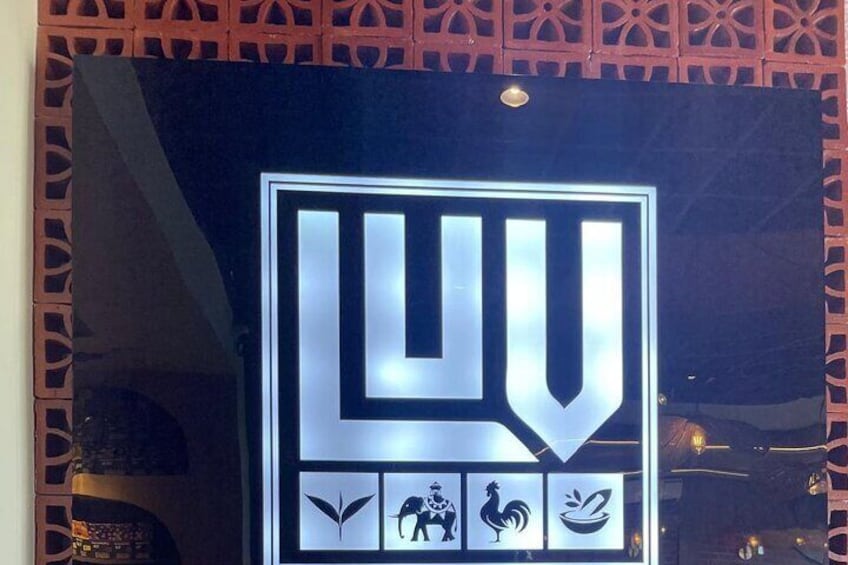 A sign with the letters "LU" and four icons below it. 4