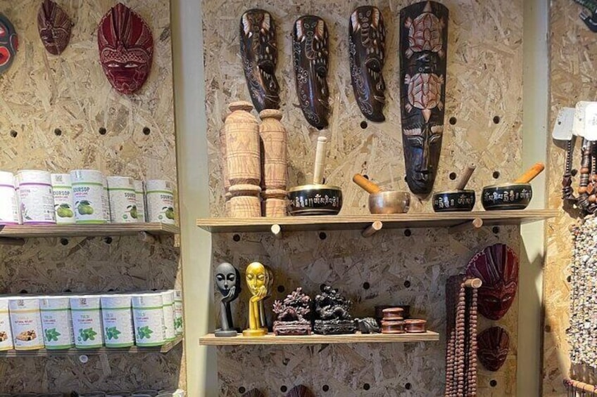 A display of masks and wooden carvings on shelves. 5