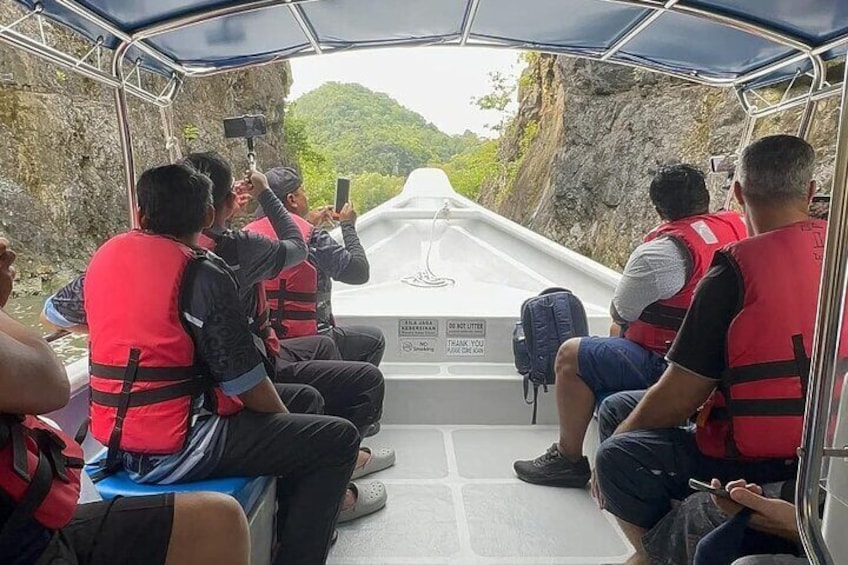 People in a boat wearing life jackets, taking photos. 2