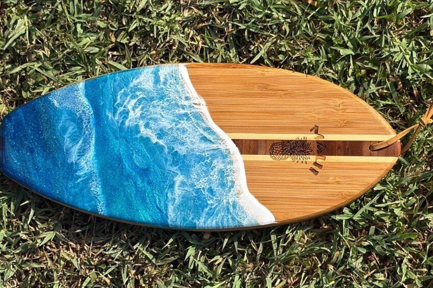 Een houten surfboard met een blauw oceaanmotief op het gras. 2