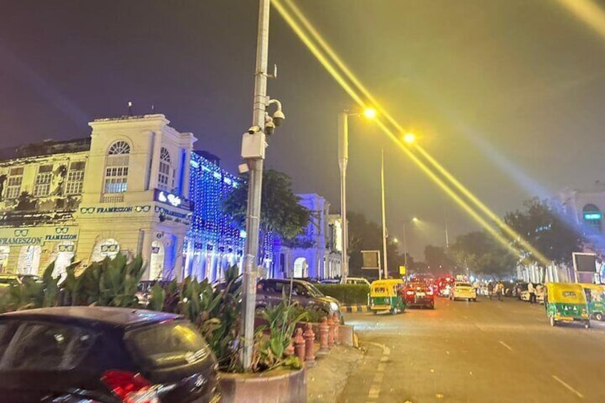 A nighttime city street with illuminated buildings and yellow taxis. 4