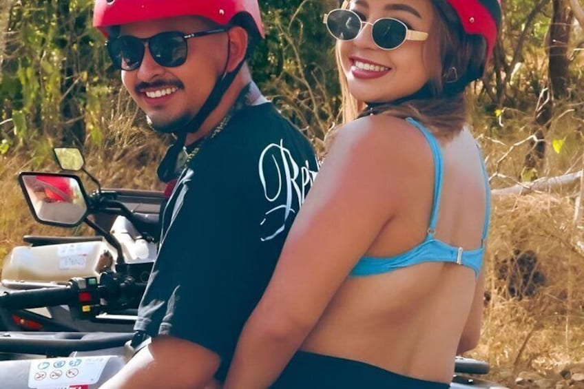 Two people on a motorcycle with a natural landscape in the background. 4
