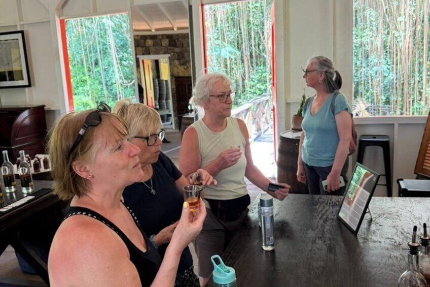 A group of people in a rustic indoor setting with wooden tables and a large window overlooking a forest. 5