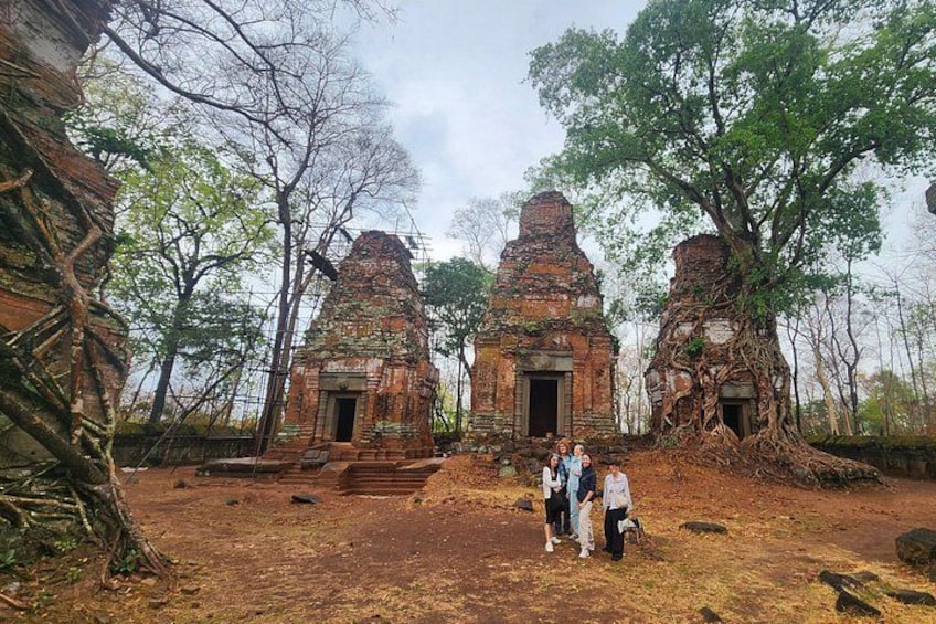 A temple with two towers, surrounded by trees and a dry ground. 1