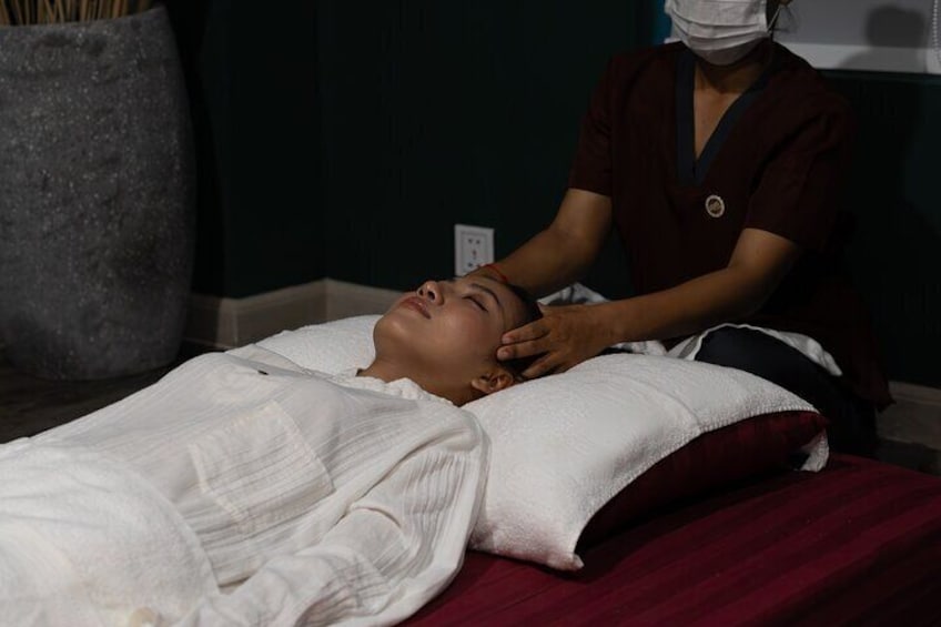 A person lying on a bed receiving a massage. 3
