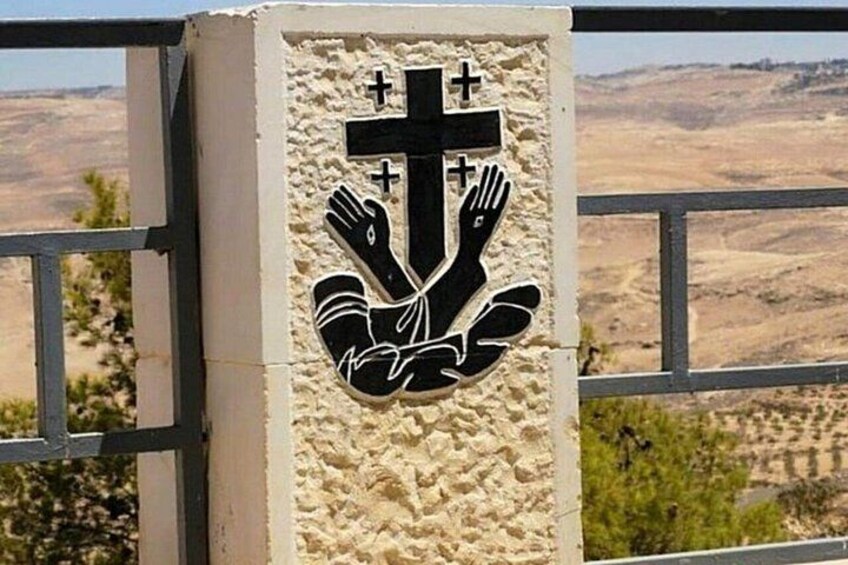 A religious symbol on a wall with a mountainous landscape in the background. 4