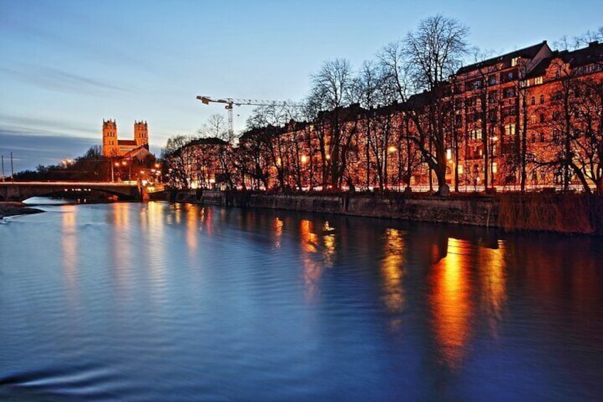 A river reflecting illuminated buildings and a tower. 4