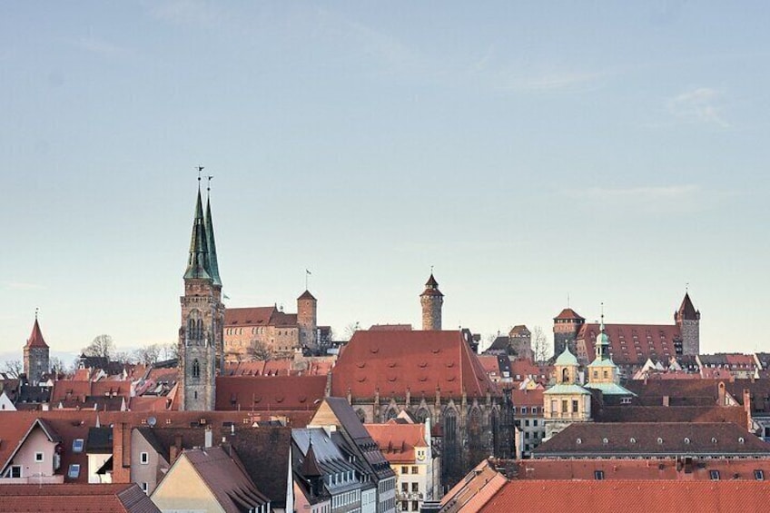 A historic town with a prominent church tower, red-roofed buildings, and a castle-like structure. 5