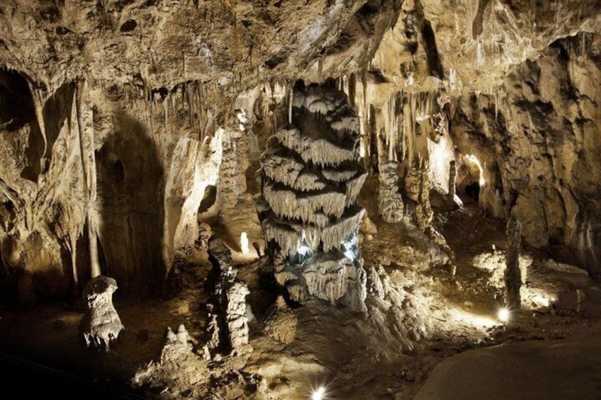 A cave with stalactites and stalagmites, illuminated by artificial lighting. 4