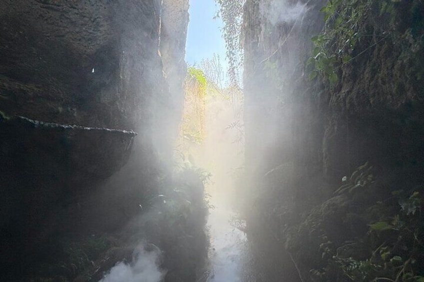A narrow canyon with water flowing through it. 3
