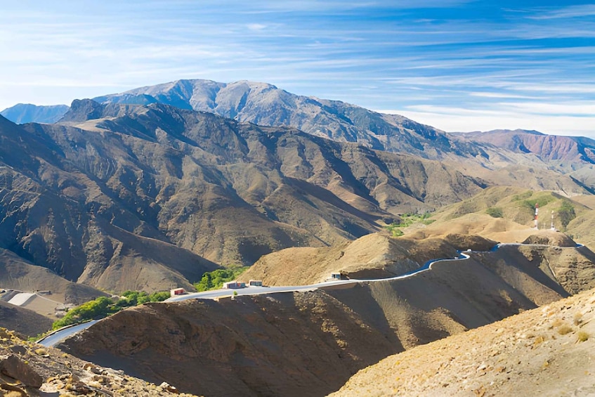 A winding road through a mountainous landscape with rocky terrain and sparse vegetation. 3