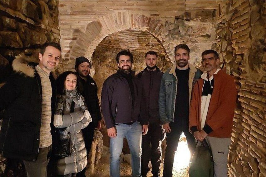 Un groupe de personnes se tient debout dans une arche en pierre. 3