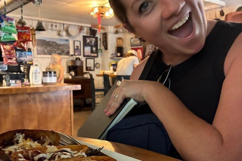 A person sitting at a table with a bowl of food, a drink, and a menu. 2