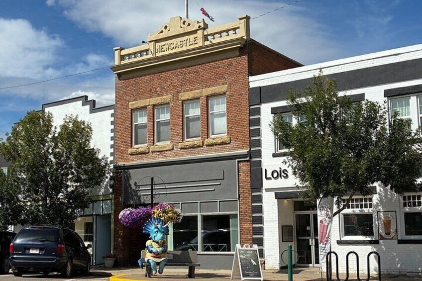 A street scene with a building labeled 'Newcastle' and another building with a sign 'Lois.' 3